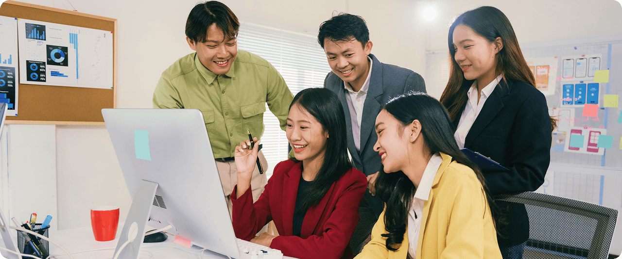 The Guerilla 360 team reviewing designs together around a desktop computer